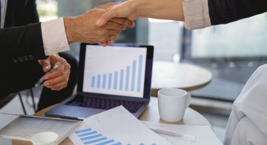 Two hands shaking hands after a process of acquisition financing.