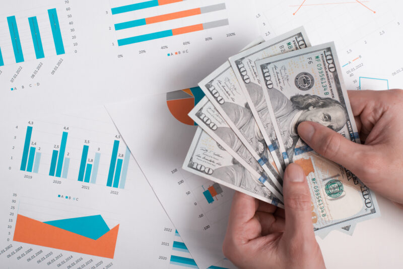 An individual counting money they have obtained from cash flow investments.