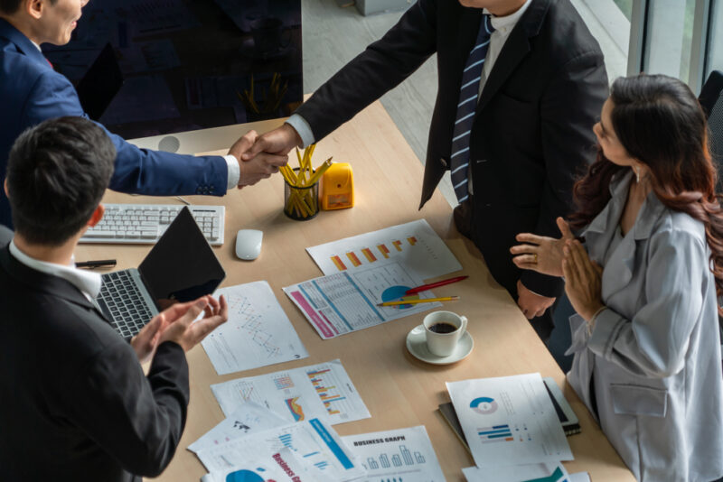 A group of people engaged in a SaaS M&A deal. 