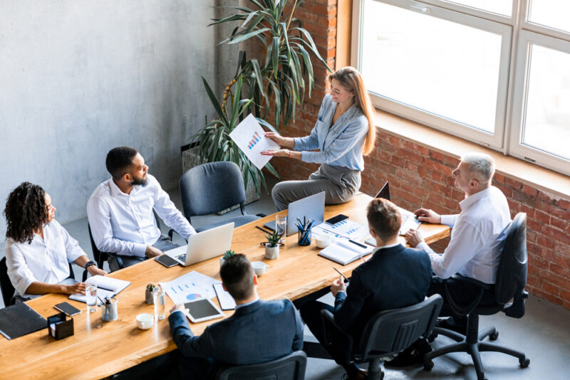 woman presenting in a meeting a strategy for income-producing assets