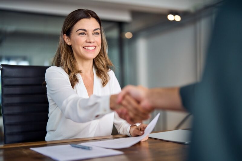 Woman shaking a hand after a SaaS investment deal