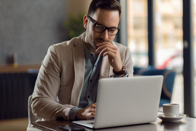 Man researching online business investment opportunities on his laptop
